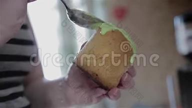 女孩厨师在一个小的复活节蛋糕上涂上一个<strong>大勺子</strong>釉。 特写烹饪食物。